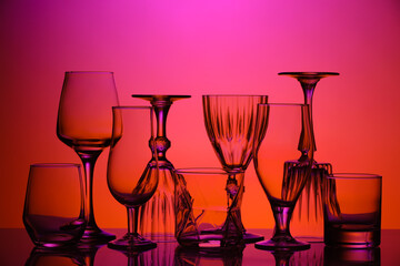 Empty glasses on color background