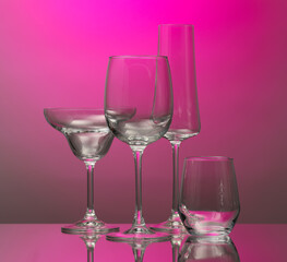 Empty glasses on color background