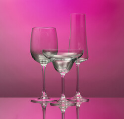 Empty glasses on color background