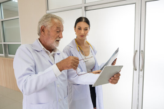Two doctors were looking at the patient's record and discussing the patient's illness.