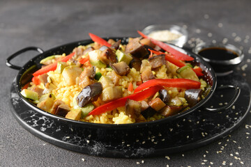 Frying pan with tasty rice on dark background