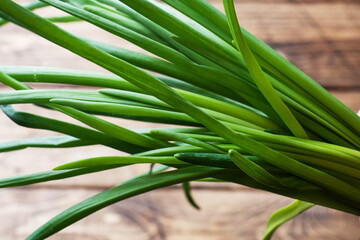 Green onions or shallots on a wooden background with copy space.