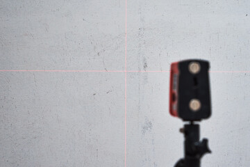Laser level checking wall, closeup. Renovation concept