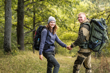 Fototapeta premium A young beautiful girl and her young man are walking in the Park, enjoying their freedom.