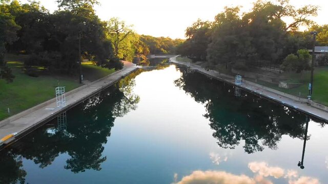 A perfectly glassy barton springs pool during summer, at golden hour. Austin Texas August 2020