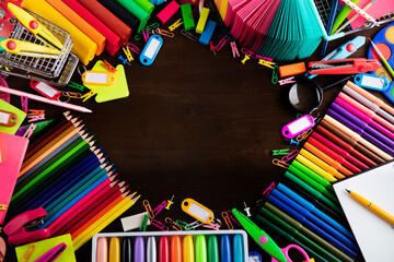 School supplies. Set of colorful school accessories isolated on the brown table. Top view.