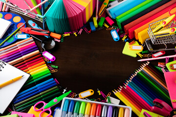 School supplies. Set of colorful school accessories isolated on the brown table. Top view.