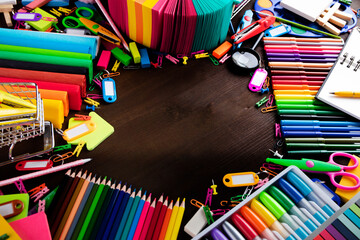 School supplies. Set of colorful school accessories isolated on the brown table. Top view.