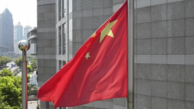 Shanghai, China - Sep 6, 2020: Chinese national flag in front of The China Development Bank (CDB). Red five star flag of China and the downtown aerial view in the background. National flag in the wind