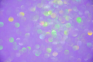 Milticolored blurred circles of lens bokeh on a violet background