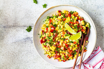 Mexican corn salad in white plate, top view, copy space. Mexican food concept.