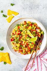 Mexican corn salad in white plate, top view, copy space. Mexican food concept.