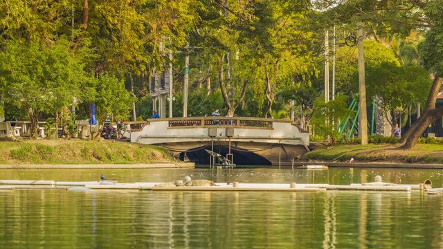 Timelapse 4k of city view from Lumpini park, Public park where is settled at the center of Bangkok and walking, jogging and running activity on the bridge.