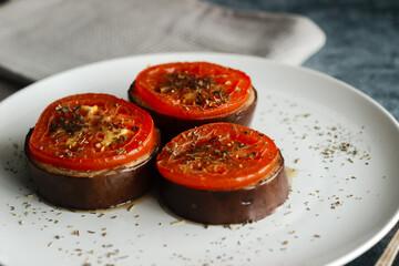 Baked eggplant with tomatoes. Eggplant on a plate. Delicious hot dish