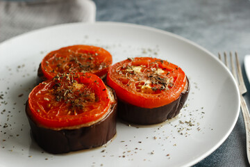 Baked eggplant with tomatoes. Eggplant on a plate. Delicious hot dish