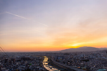 山に沈む夕日と住宅地と河川