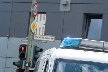 Blaulicht eines Polizeifahrzeug vor einer roten Fussgängerampel in der Invaliedenstrasse in Berlin-Mitte