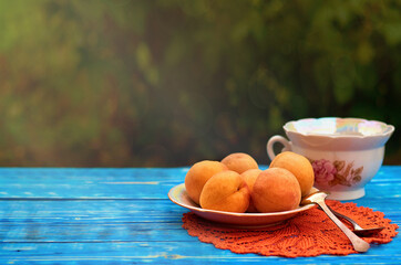 fresh orange apricots on a plate on a blue wooden background. harvested crop