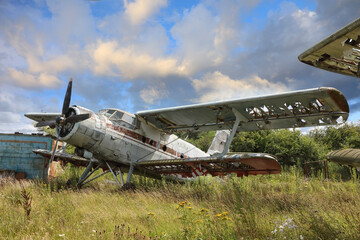 Airplane cemetery in the field against cloudy blue sky