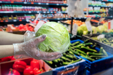 buyer in gloves chooses vegetables during a pandemic due to a new dangerous virus, coronavirus