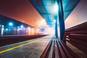 Treno in partenza dalla stazione ferroviaria nella notte nebbiosa