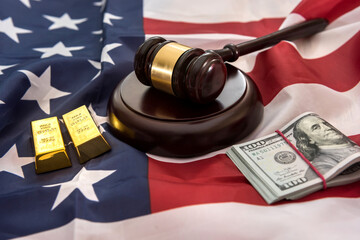 gold bars with justice law hammer lying on usa flag