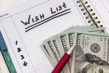 text wish list  on notepad with dollar bills