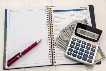 calculator and pen with empty sticker on dollar bills