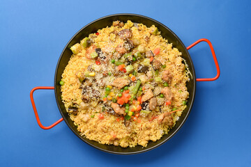 Frying pan with tasty rice on color background