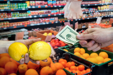  buyer giving money to the saleswoman for the fruits in supermarket