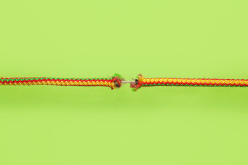 Frayed rope on color background