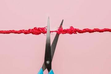 Scissors with frayed rope on color background - obrazy, fototapety, plakaty