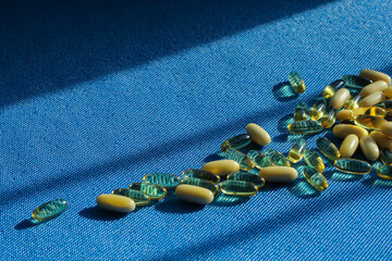 Transparent tablet capsule on blue background with shadows.