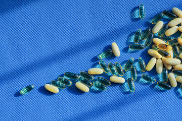 Transparent tablet capsule on blue background with shadows.