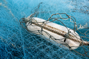 Fishing net or cast net, drying out on the dockyard in evening tropical sun
