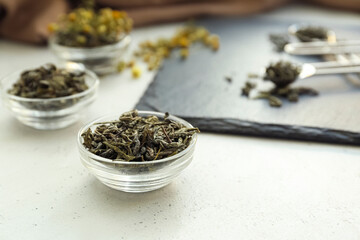 Bowl with dry tea leaves on table