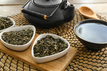 Cup of tea with teapot and dry leaves on table