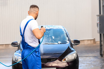 Fototapeta na wymiar Male worker washing car outdoors