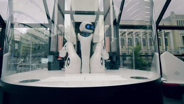 Futuristic robot, innovative technology concept. Coffee-serving robot is moving its arms while working