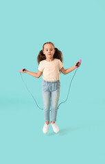 Cute little girl jumping rope against color background