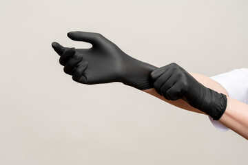 Chef hands. Kitchen hygiene. Woman wearing black latex gloves isolated on light copy space...