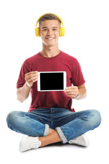 Teenage boy with headphones and tablet computer on white background