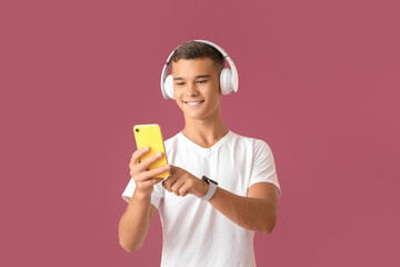 Teenage boy listening to music on color background