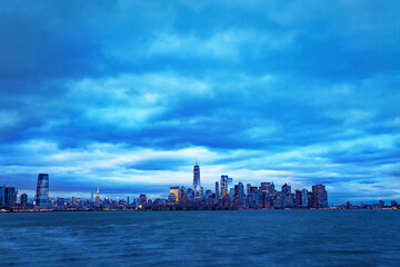 Obraz premium Dramatic panorama of New York Manhattan downtown over Hudson from Jersey City overcast day