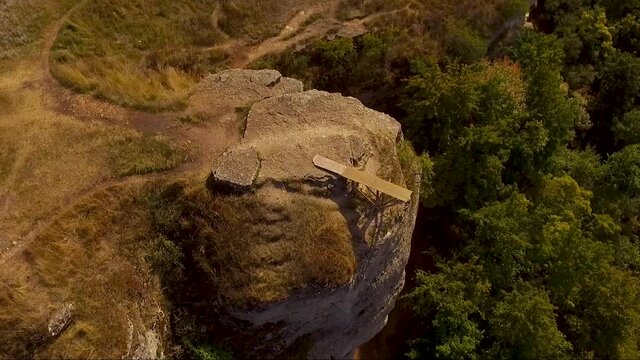 A small wooden bridge on the edge of a rocky cliff. Aerial shot