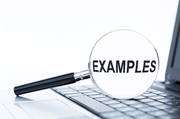 A concept image of a magnifying glass isolated white background with a word EXAMPLE zoom inside the glass on laptop keyboard