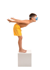 Little boy in start position on swimming block against white background