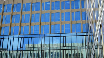 Office building, blue glass wall reflection detail. Modern office building and clear sky background. 