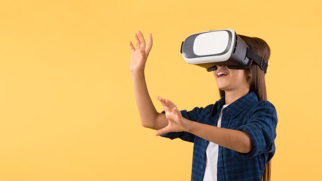 Little girl wearing virtual reality goggles at orange studio