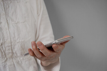 An elderly person using a smartphone. Close-up of an elderly person who is worried about how to use a smartphone.  スマートフォンを使う高齢者。スマホの使い方について悩むシニア。